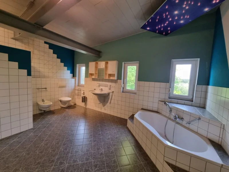 Wellness Zuhause im Bad mit Bodengleicher Dusche , Eckwanne , Waschbecken und  Handtuchheizkörper
