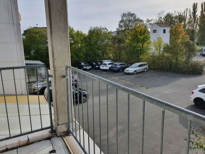 Blick vom überdachten Balkon zum Parkplatz