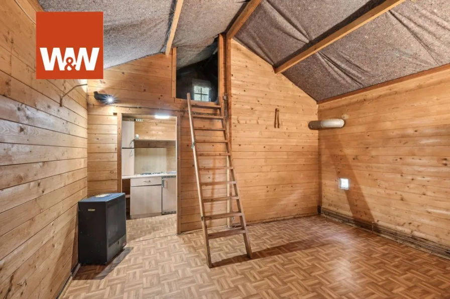 Holzhaus mit Schlafempore über Leiter erreichbar
