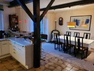 charmanter Esszimmerbereich mit offener Küche und Zugang zur Terrasse