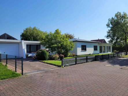 Hausfront mit großer PV-Anlage auf dem Garagendach - Haus kaufen in Büsum - Charmanter, gemütlicher Bungalow mit zwei mögl. ELW auf Eigenland