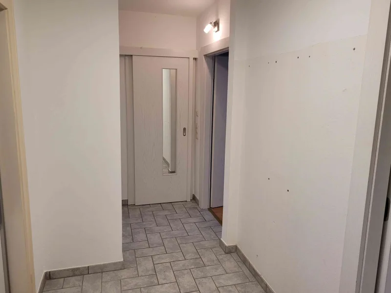 Wohnungsflur mit Blick zum Badezimmer und maßangefertigtem großen Wandschrank