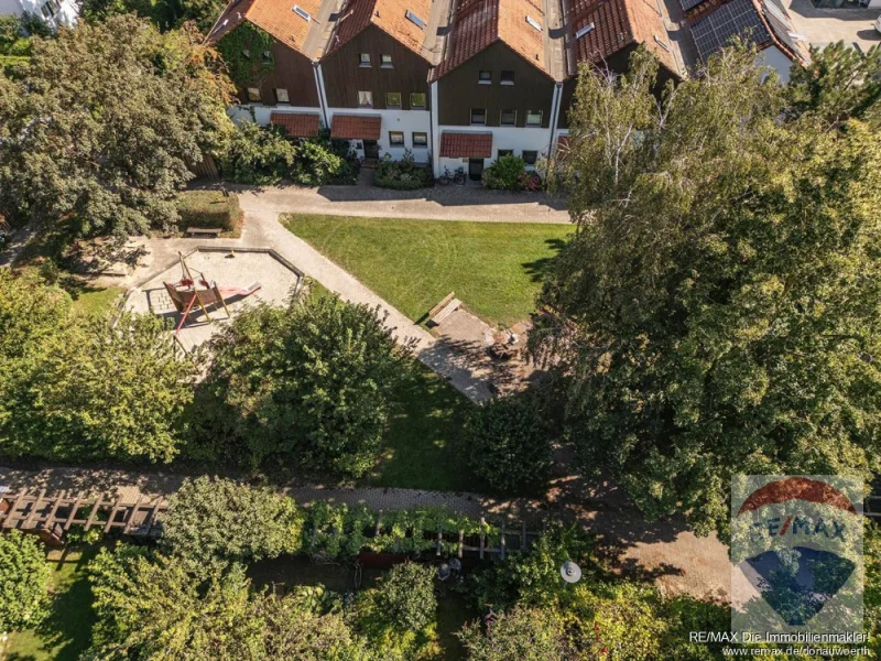 Blick über die Gartenpergola zum Spielplatz mit der nächsten Hausreihe