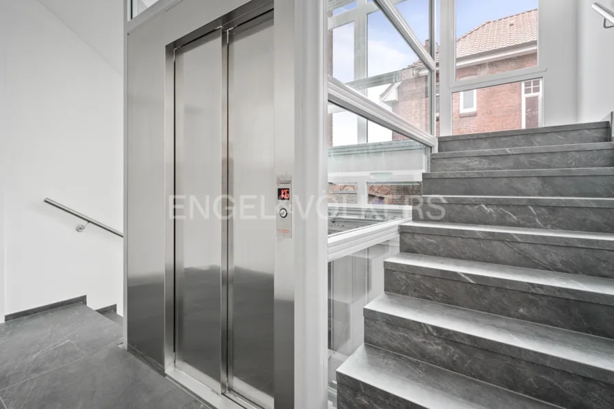 Treppenhaus mit verglastem Aufzug