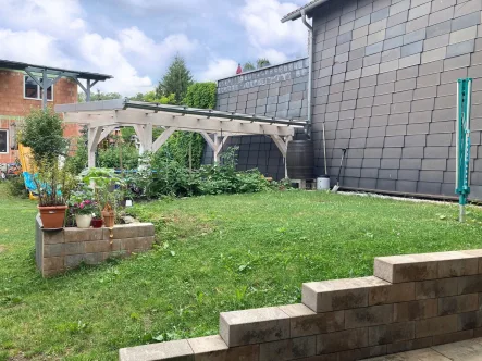 Blick in den Garten mit Freisitz und Neubau Wohnhaus - Zinshaus/Renditeobjekt kaufen in Geratal - Land – Genuss – Leben