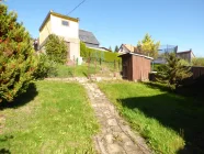 Garten mit Garage an der oberen Grundstücksgrenze