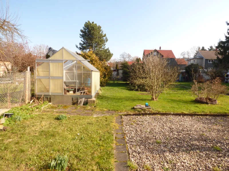 Blick in den Garten mit Gewächshaus