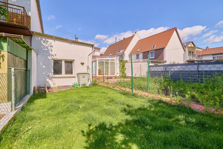 Garten hinter dem Haus mit Blick auf Garage und Wintergarten - Haus kaufen in Neuhofen - RESERVIERT: Gepflegtes, freistehendes Eigenheim mit schönem Garten!