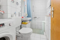 Das Badezimmer mit Wanne, Waschbecken , Waschmaschine und Toilette