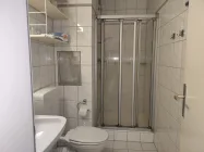 Das Badezimmer mit integriertem Föhn und einer Dusche, WC, und Waschbecken
