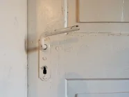 Die originale Holztür zu einem der Zimmer im Obergeschoss