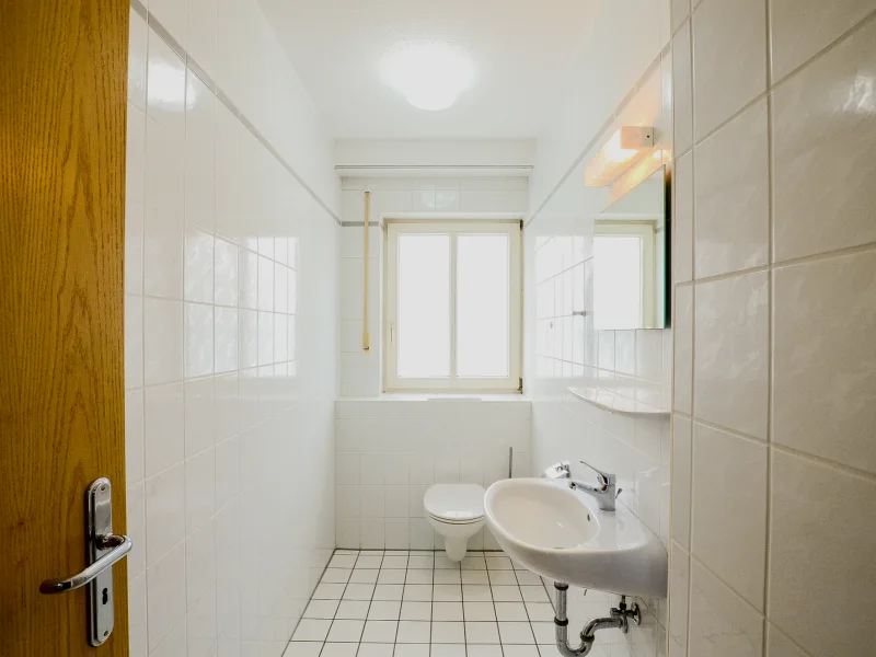 Eines der separaten WCs mit Waschbecken und Fenster