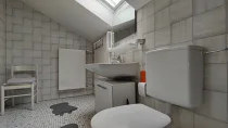 Das helle Tageslicht-Badezimmer mit einem Waschbecken, WC und Dusche