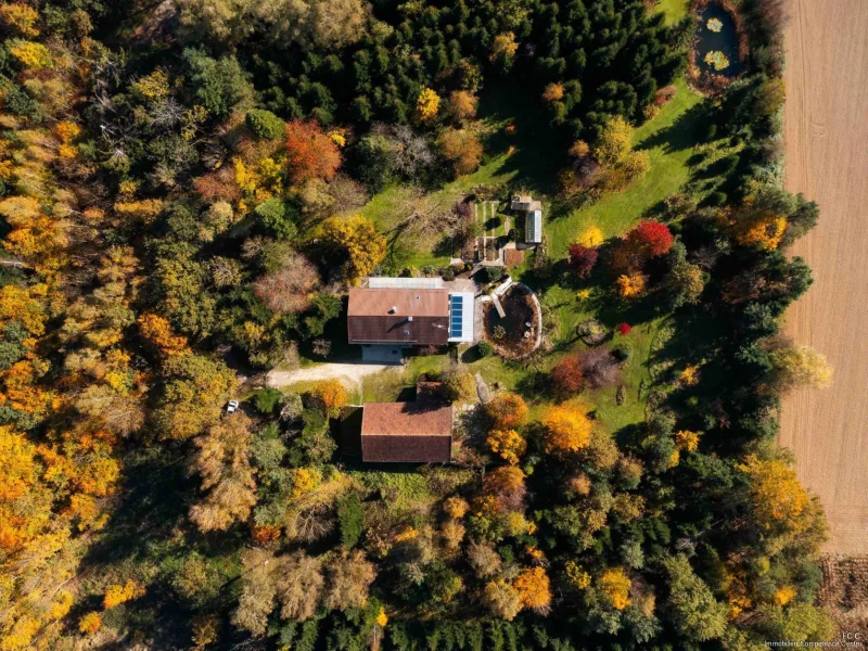 Das Grundstück aus der Vogelperspektive mit Blick auf Scheune, Haus, Teiche und Wald