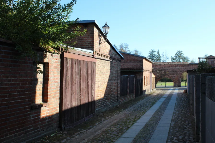 Grundstücksmauer mit Stadtmauer im Hintergrund