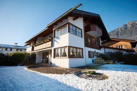 Hausansicht mit Garten - Wohnung kaufen in Garmisch-Partenkirchen - Ruhige EG-Wohnung mit 3 Zimmern und wunderbarem Bergblick inkl. Terrasse, Garten und TG-Stellplatz