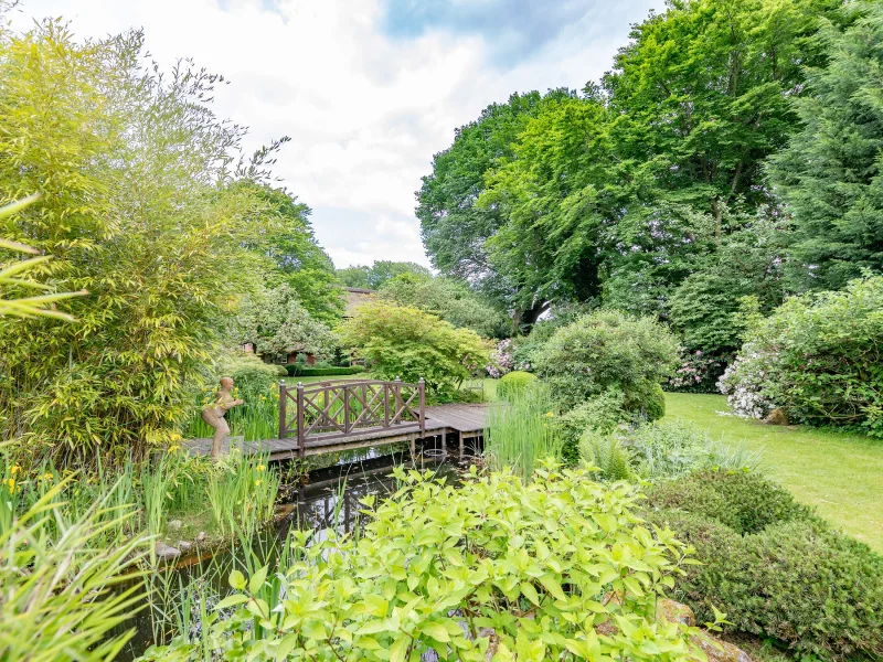 Ein kleiner See mit Brücke schmückt den tollen Garten