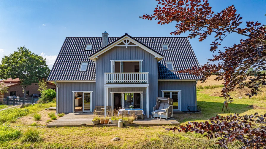 Hausrückseite mit Terrasse und Balkon