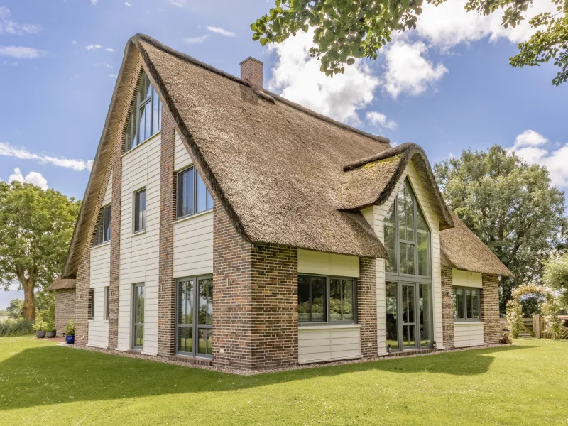 Seitenansicht - Haus kaufen in St. Peter-Ording - Tradition trifft Moderne: Exklusives Reetdachhaus in Alleinlage - mit Ferienwohnung