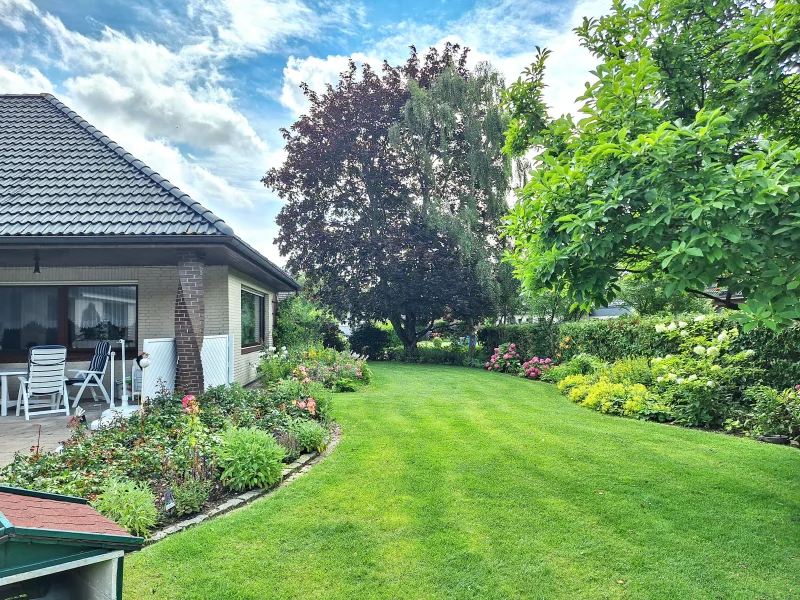 Seitenansicht mit Garten - Rasenroboter - Haus kaufen in Brunsbüttel - Willkommen Zuhause | Einfamilienhaus in ruhiger Lage