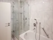 Badezimmer mit einer Badewanne und einer Dusche