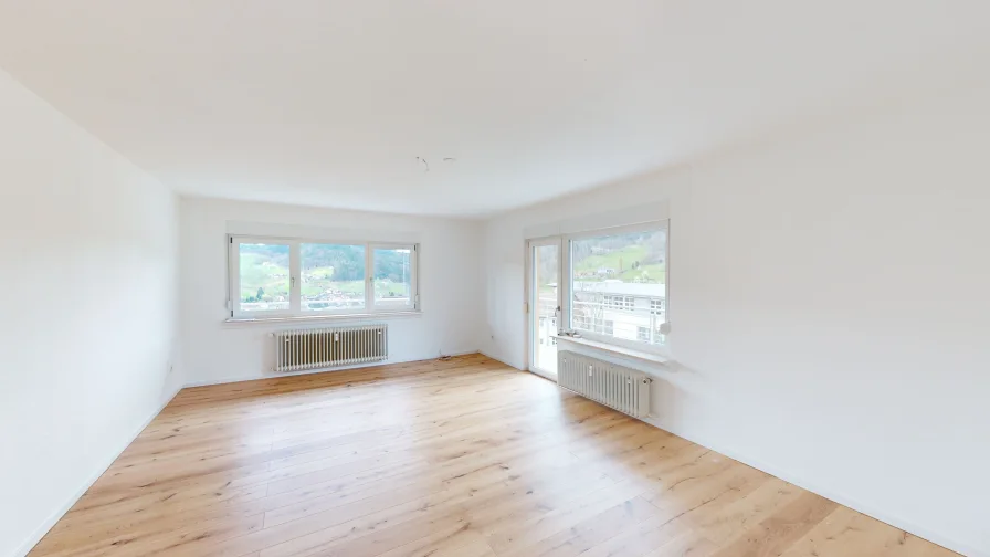 Wohnzimmer mit Zugang zum Balkon - Wohnung kaufen in Ottenhöfen - Bergidylle: Renovierte Wohnung mit weitem Ausblick