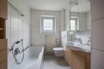 Renoviertes Badezimmer mit Wanne und Fenster im Erdgeschoss