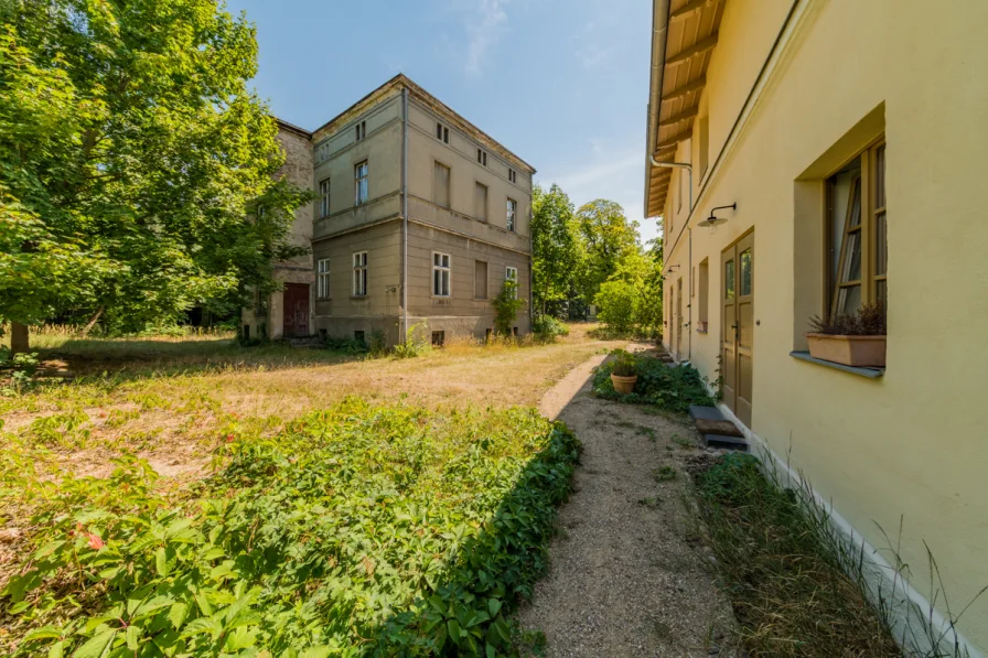 Außenansicht der Remise mit der Villa Rabe im Hintergrund