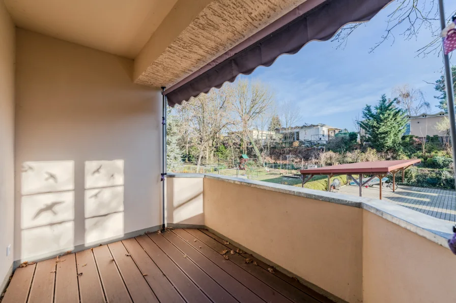 Großzügiger überdachter Balkon mit Gartenblick