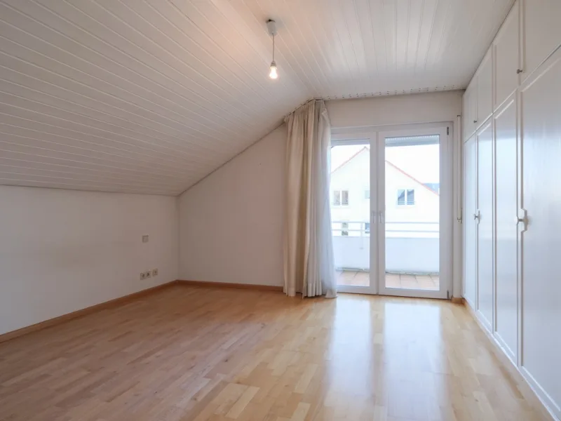 Schlafzimmer mit Einbauschrank und Zugang zum Balkon