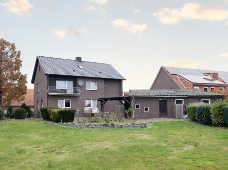 Gartenansicht - Haus kaufen in Alfhausen - Großzügiges Einfamilienhaus auf sonnigem Grundstück mit Bauplatz für zukünftige Projekte!