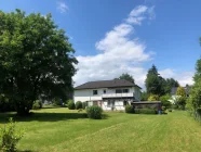 Gartenansicht mit Haus- und Garagenrückansicht