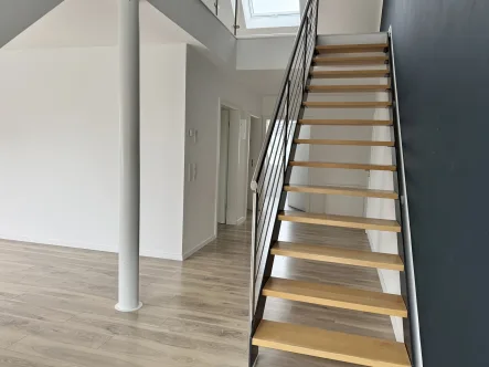 Wohnzimmer mit Treppe zum Spitzboden - Wohnung mieten in Rheda-Wiedenbrück - Moderne Dachgeschosswohnung mit Galerie in zentraler Lage von Rheda-Wiedenbrück