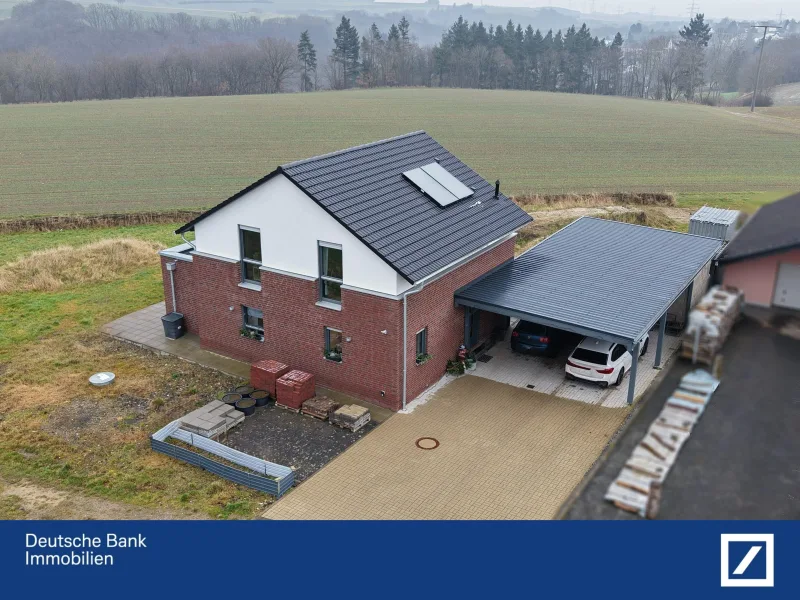 Giebelseite und Carport - Haus kaufen in Dünfus - Junges Einfamilienhaus mit lichtdurchfluteten Räumen, moderner Ausstattung und großem Garten!