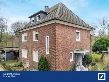 Straßenansicht - Haus kaufen in Gütersloh - Traumhafte Lage direkt am Mohnspark! Zweifamilienhaus mit Ausbaureserve, Garage und schönem Garten