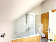 Badezimmer mit Badewanne und WC