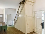 Flur mit Treppenaufgang zum Dachboden, Kellerabgang und Zugang zur Küche (rechte Tür) und vor der Treppe Zugang zum Badezimmer