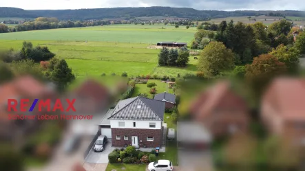 Luftaufnahme - Haus kaufen in Bad Münder - Moderne Stadtvilla (Bauj. 2019) am Dorfrand mit Panoramablick auf den Süntel und angrenzende Weiden