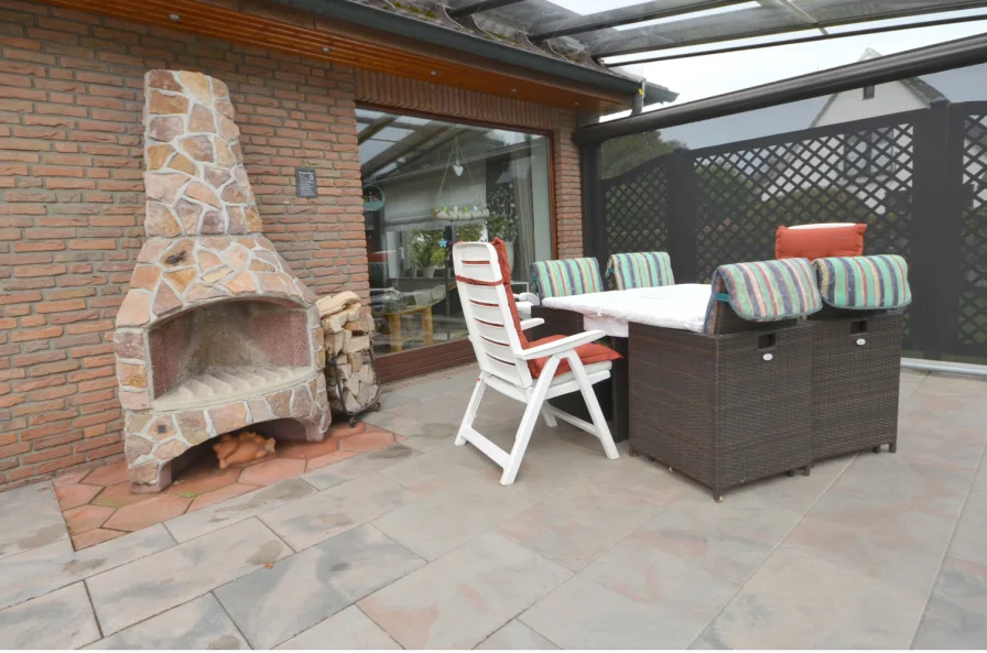 Große Südterrasse mit Glasdach, Wind- und Sonnenschutz sowie einem Außenkamin