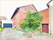 Ansicht Backsteinhaus und Garage mit Terrasse