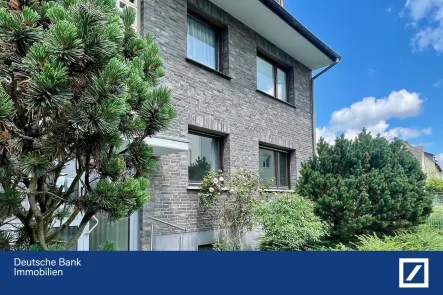 Ansicht mit schönem Vorgarten - Wohnung kaufen in Hilden - Glück im Grünen: Terrassen-Wohnung mit Garage, zentral + ruhig