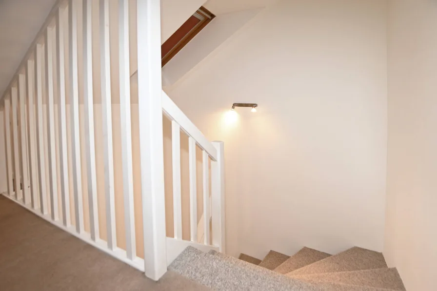 Beleuchtete Treppe führt vom Spitzboden zum Obergeschoss