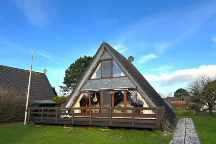 Vorderansicht mit Terrasse - Haus kaufen in Butjadingen - Teilsaniertes Ferienhaus aus erster Hand in ruhiger Ecklage, nur wenige Minuten vom Deich und Hafen entfernt!