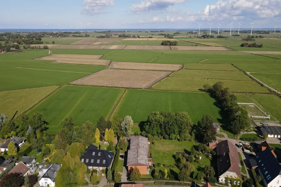 Drohnenaufnahme - Haus kaufen in Butjadingen - Nordsee-Idylle in Tossens - sehr umfangreich saniertes Reihenendhaus mit Balkon und Garten!