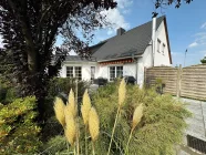 Blick aus dem Garten auf die Terrasse