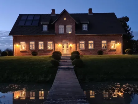 Ansicht des Anwesens in der Dämmerung zeigt die Beleuchtung und vermittelt eine warme, einladende Atmosphäre - Haus kaufen in Neukirchen - Ein exklusives Anwesen vor den Toren von Sylt ab sofort für Sie bereit. Maklerprovision reduziert!