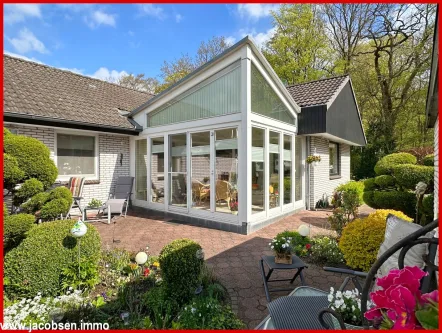 Südansicht mit Wintergarten - Haus kaufen in Kropp - Ebenerdig und ruhig wohnen - Winkelbungalow für alle Lebensphasen mit repräsentativem Garten