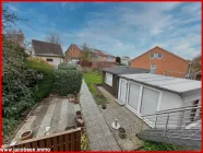 Blick vom Balkon in den Garten mit Gartenhäusern