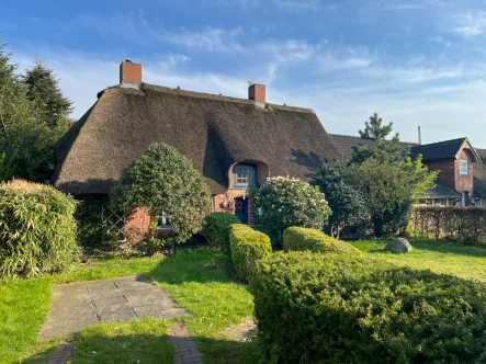 Ansicht vorne - Haus kaufen in Langenhorn - Ein Reetdachhaus, wie es im Buche steht: wohnlich, gemütlich, mit viel Platz und Natur.