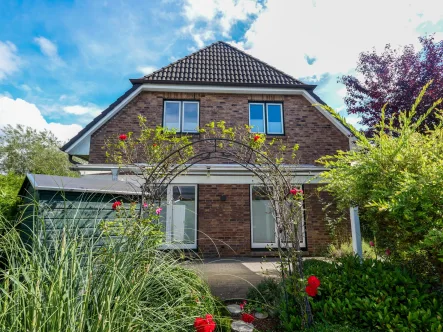 Rückwärtige Hausansicht - Haus kaufen in Groß Nordende - Vermietetes Einfamilienhaus mit Blick über Felder und Wiesen